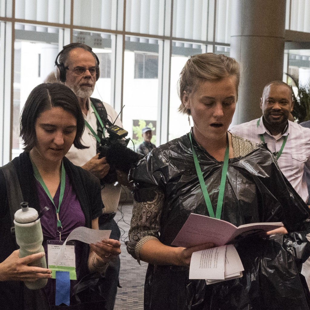 Members of the Mennonite USA wear garbage bags during the hymn sing outside the delegate assembly, symbolizing the de-pinking of the delegate assembly, a visual representation of the silencing LGBTQ community.